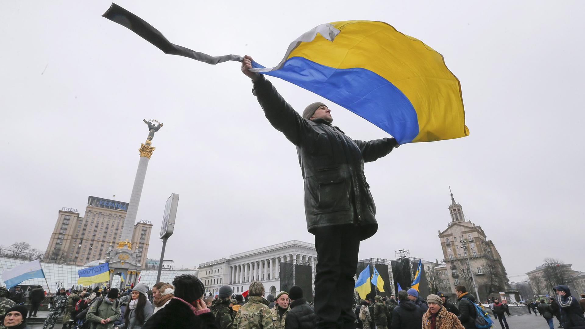 Mann mit ukrainischer Flagge auf dem Maidan in Kiew