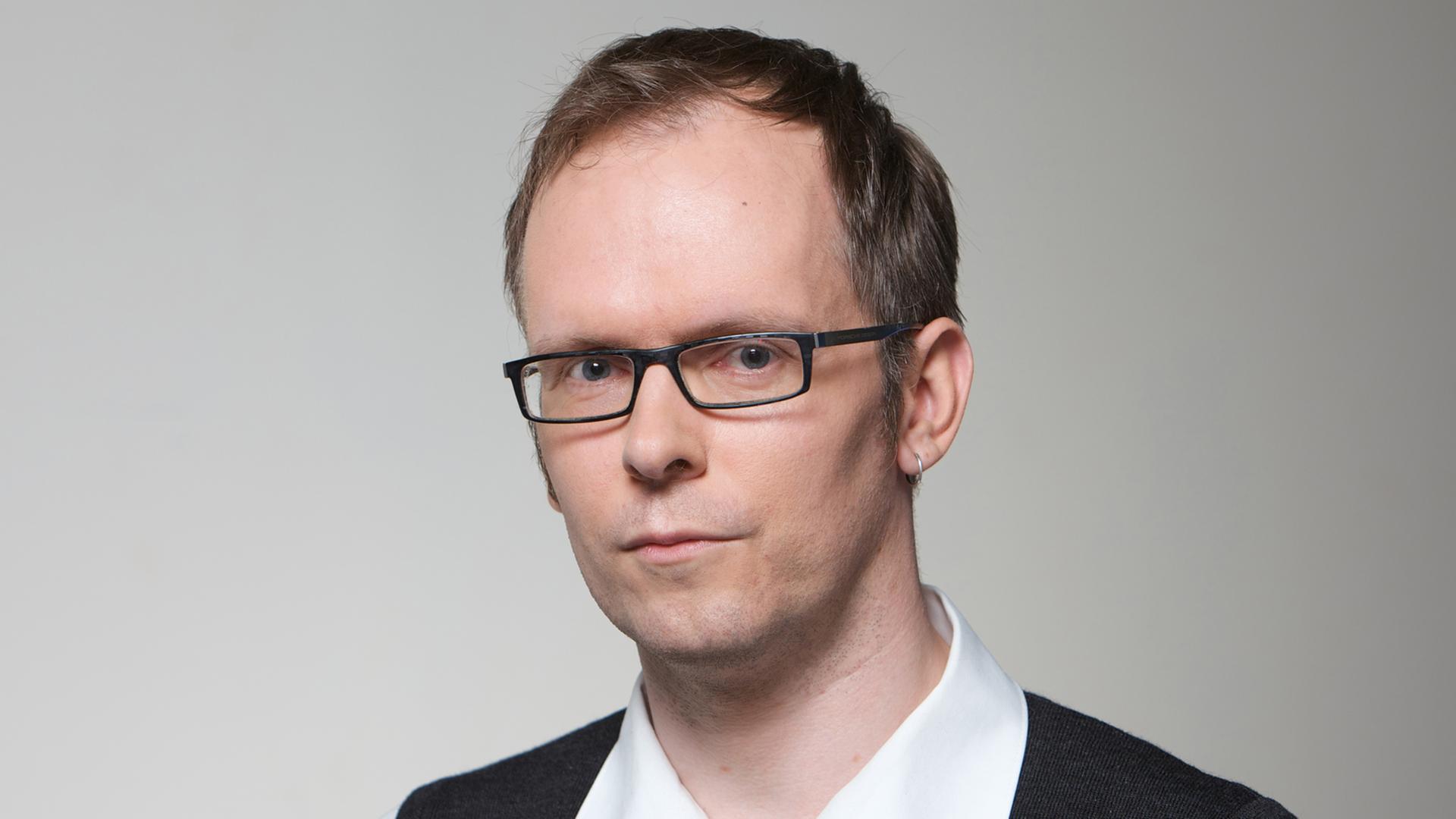 Der Autor und Journalist Dietmar Dath trägt auf dem Porträtbild ein weißes Hemd unter schwarzem Pullunder