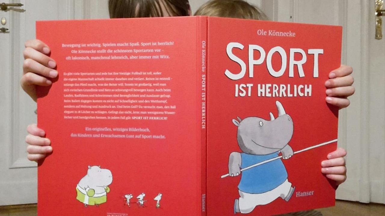 Die Autorin schaut gemeinsamt mit ihrer Tochter in das Bilderbuch "Sport ist herrlich".
