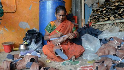 Schuhproduktion in Indien: Die Mittlerin Chinamma kontrolliert die angelieferten Oberteile der Heimarbeiterinnen.