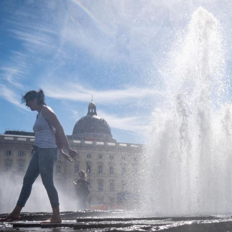 Berlin: Eine Passantin erfrischt sich im Brunnen im Lustgarten bei hohen Temperaturen.