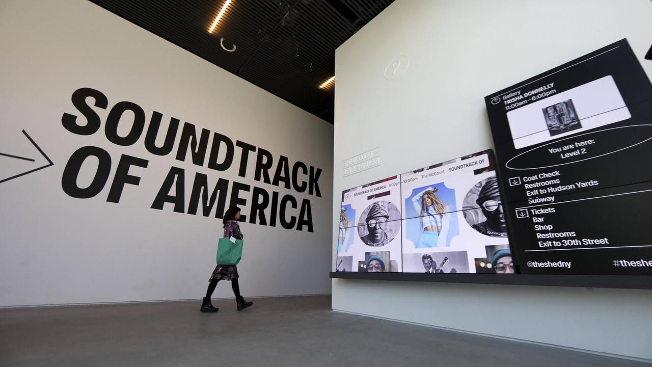 Eine Besucherin geht durch die Ausstellung "Soundtrack of America"