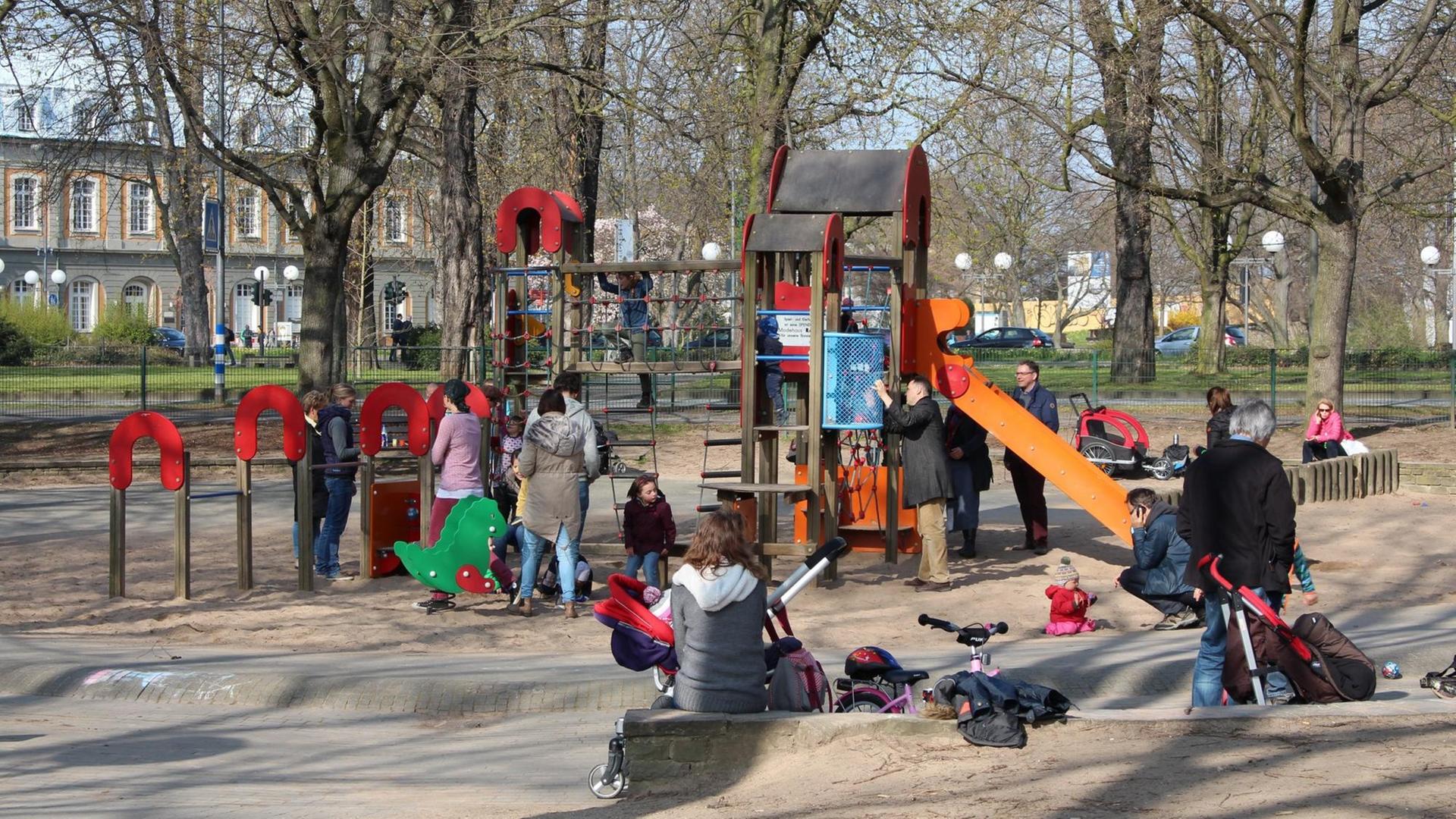 Kinder schaukeln und klettern auf einem Spiel-Platz
