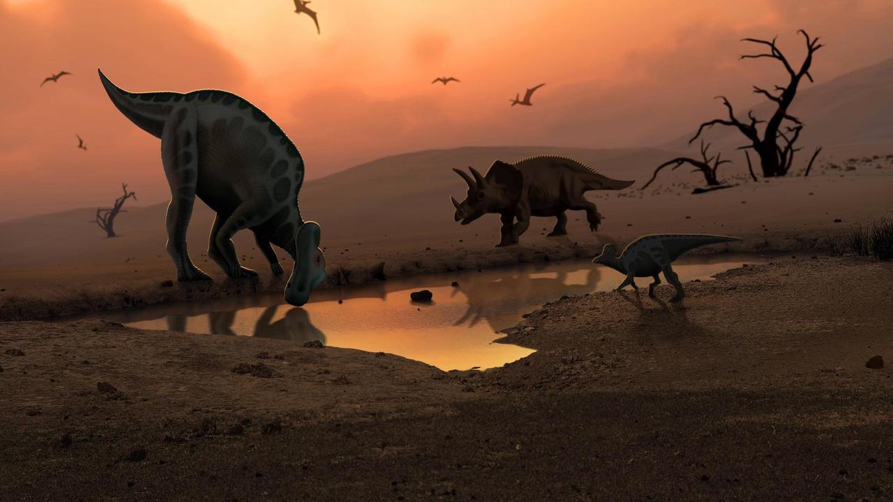 Drei Dinosaurier stehen in einer verwüsteten Szenerie an einem kleinen verbliebenen Wasserloch