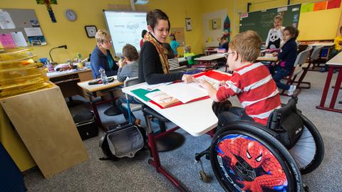 In einer Schul-Klasse sitzt ein Junge im Rollstuhl.