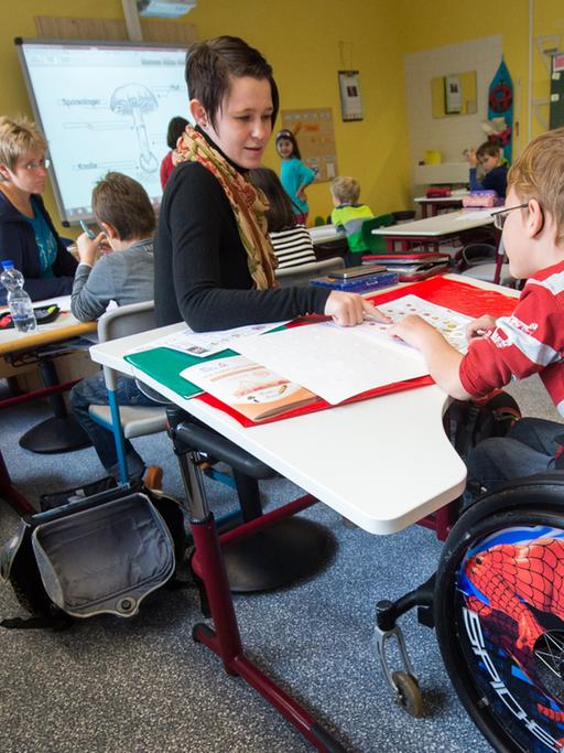 In einer Schul-Klasse sitzt ein Junge im Rollstuhl.