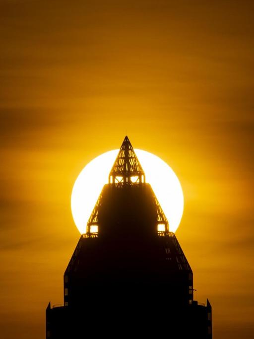 Die Sonne geht hinter dem Messeturm unter.