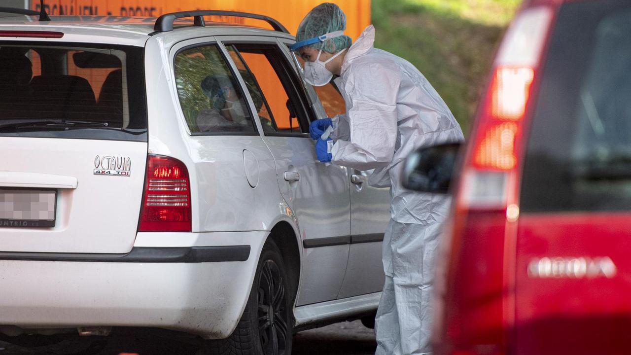 Ein Sanitäter des tschechischen Universitätsklinikums Hradec Kralove führt einen Corona-Test bei einer Person im Auto durch.