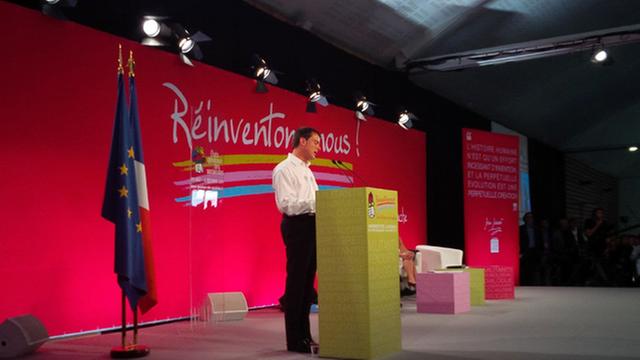 Manuel Valls bei seiner Rede auf dem Parteitag der Sozialisten in Frankreich am 31. August 2014, an einem Rednerpult stehen vpr einer roten Wand mit der Aufschrift "Reinventons nous", übersetzt: Lasst uns uns neuerfinden