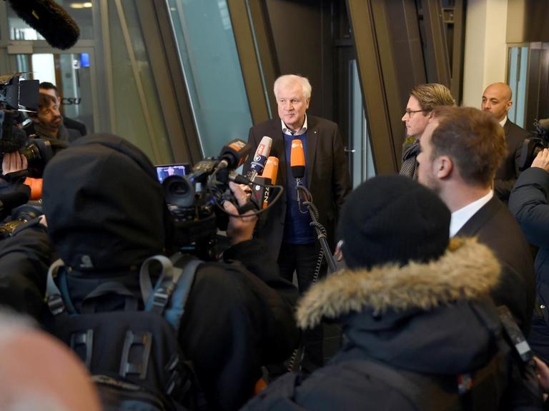 Seehofer umringt von Kameras und Mikrofonen der Journalisten.