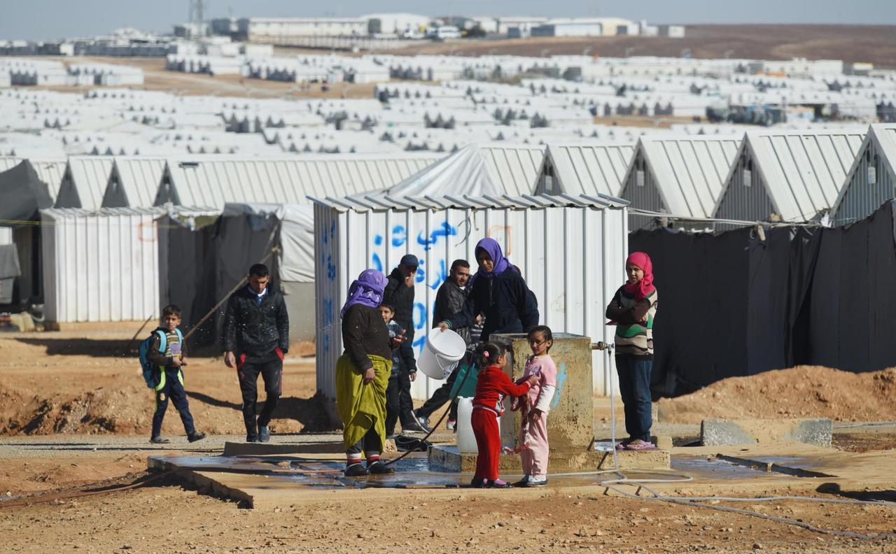 Frauen und Kinder vor den Hütten des UNHCR.Flüchtlingslagers in Azraq in Jordanien.