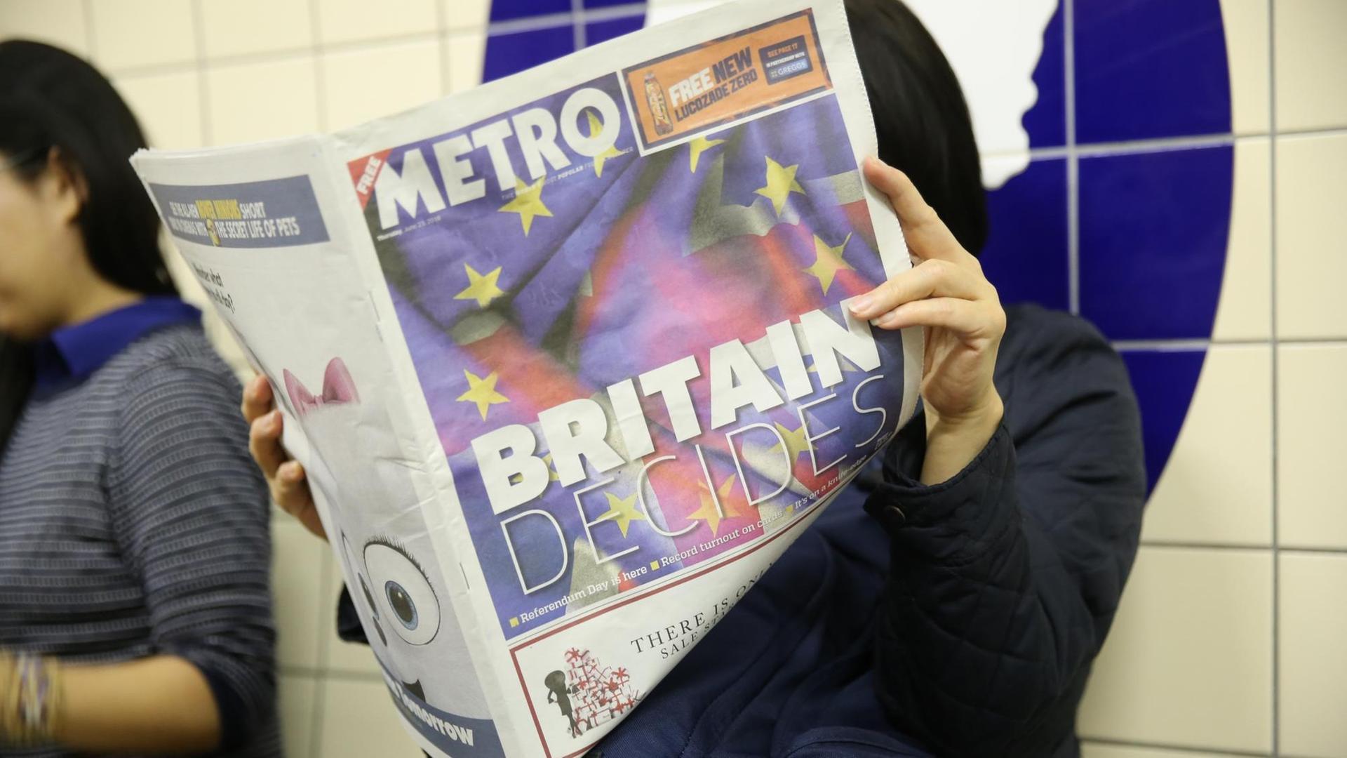 Eine Frau liest am 23.06.2016 in London in der U-Bahn vor dem Referendum über den Austritt oder Verbleib Großbritanniens in der EU im kostenlosen Infoblatt "Metro", das mit der Überschrift "Britain Decides" titelt. Rund 46 Millionen Wähler bestimmen am 23.06.2016, ob ihr Land in der EU bleiben soll.