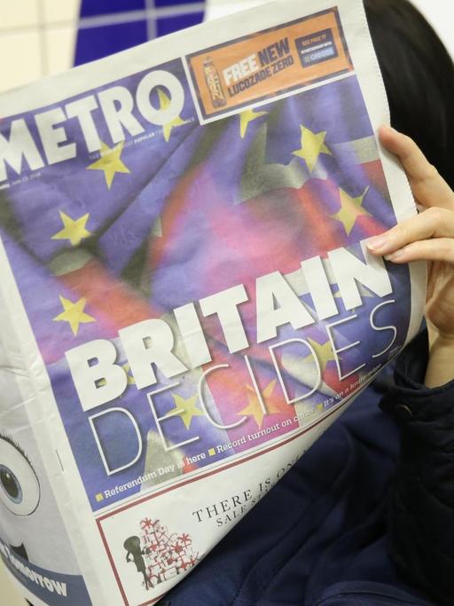 Eine Frau liest am 23.06.2016 in London in der U-Bahn vor dem Referendum über den Austritt oder Verbleib Großbritanniens in der EU im kostenlosen Infoblatt "Metro", das mit der Überschrift "Britain Decides" titelt. Rund 46 Millionen Wähler bestimmen am 23.06.2016, ob ihr Land in der EU bleiben soll.