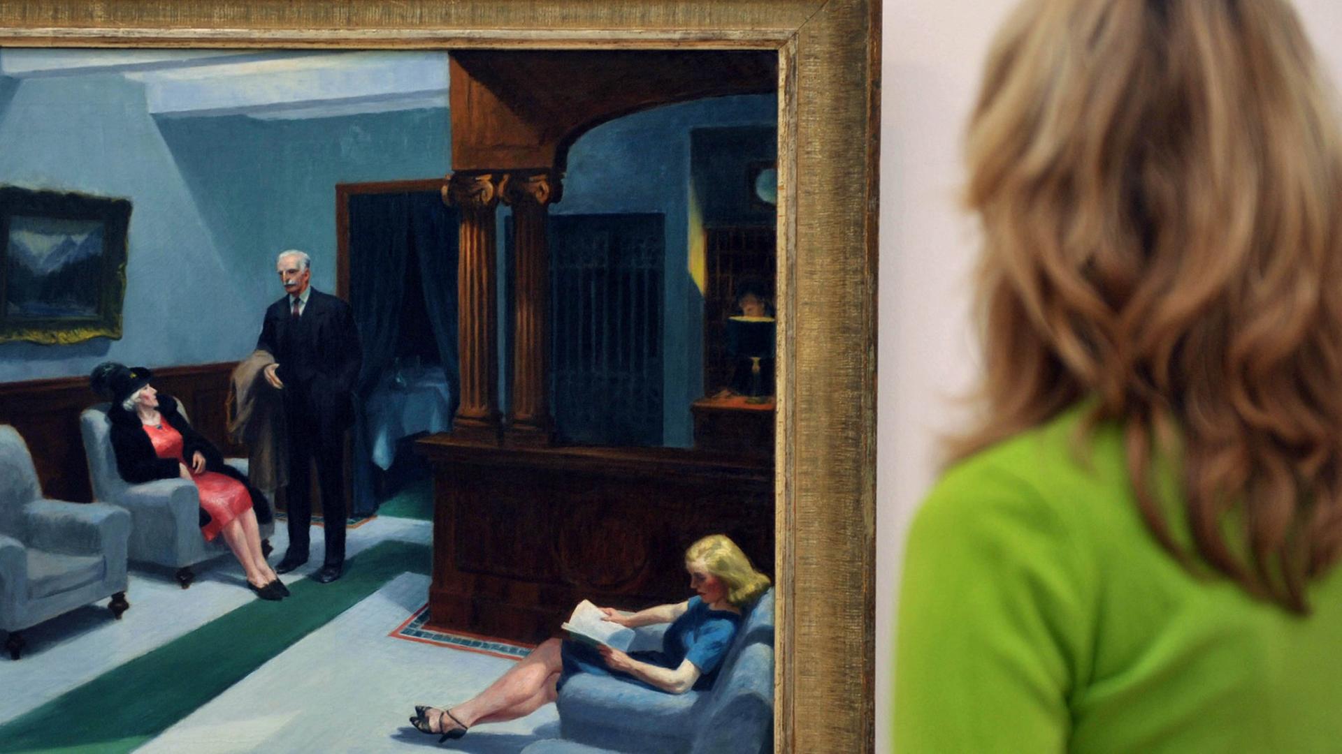 Eine Frau schaut sich ein Bild aus der Ausstellung "Realismus - Das Abenteuer der Wirklichkeit" an.