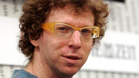 Porträtbild von Arnon Grünberg mit Brille und Lockenkopf