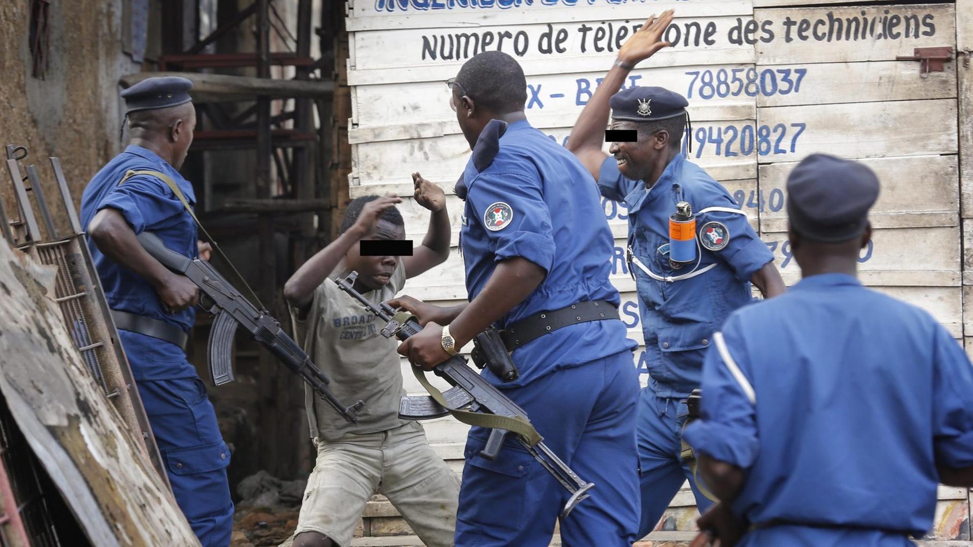 Man sieht, wie Polizisten einen Jungen in Burundis Hauptstadt Bujumbura schlagen.