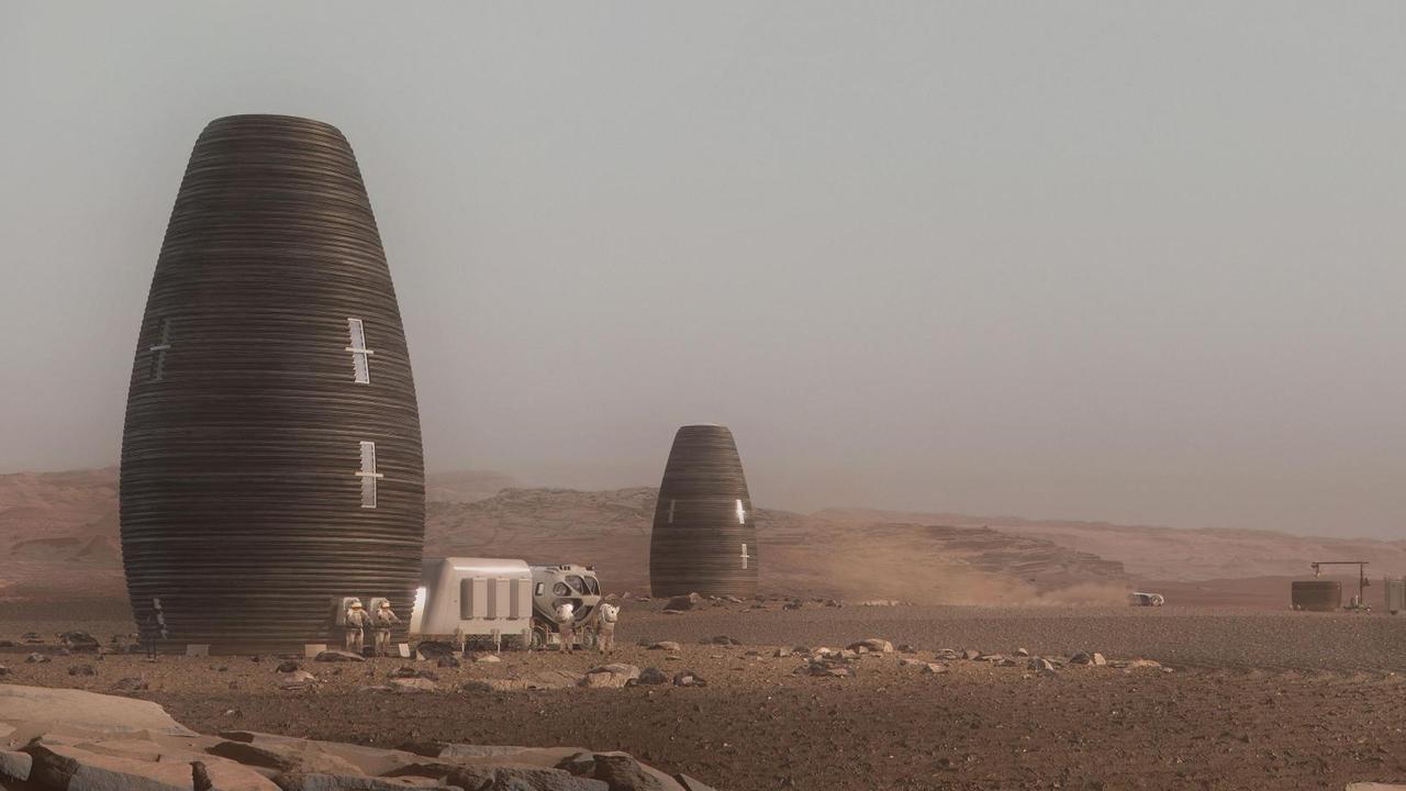 Silo-artige, wie einem Science-Fiction-Film entnommen wirkende Wohngebäude in einer Wüstenlandschaft.