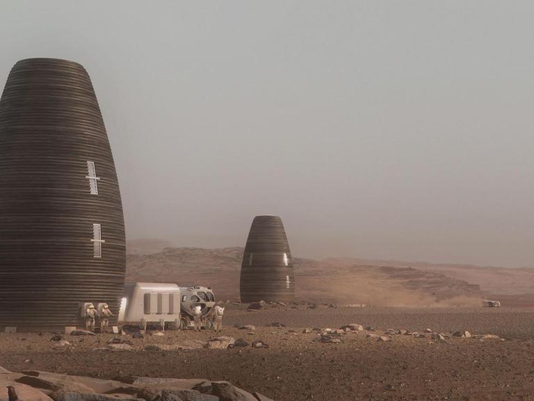 Silo-artige, wie einem Science-Fiction-Film entnommen wirkende Wohngebäude in einer Wüstenlandschaft.