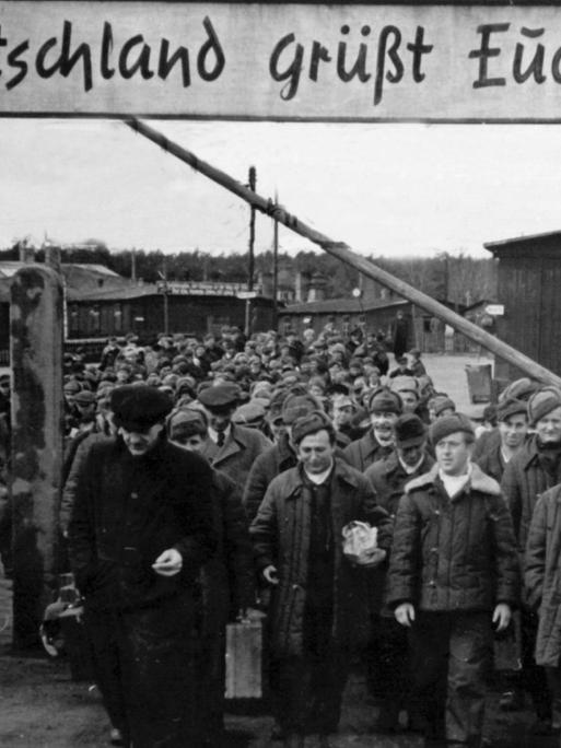 "Deutschland grüßt Euch" steht auf einem Schild über dem geöffneten Schlagbaum des Entlassungslagers Gronenfelde bei Frankfurt an der Oder. Die aus russischer Kriegsgefangenschaft entlassenen Heimkehrer treten von hier aus die Reise in ihre Heimatorte an. Aufgenommen am 12. April 1949.