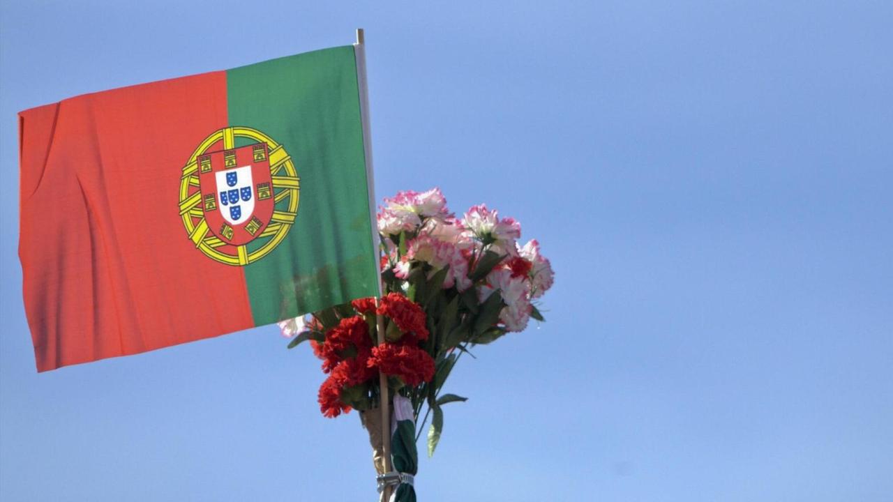 Nelken und eine portugiesische Flagge zum Gedenken an die Nelkenrevolution