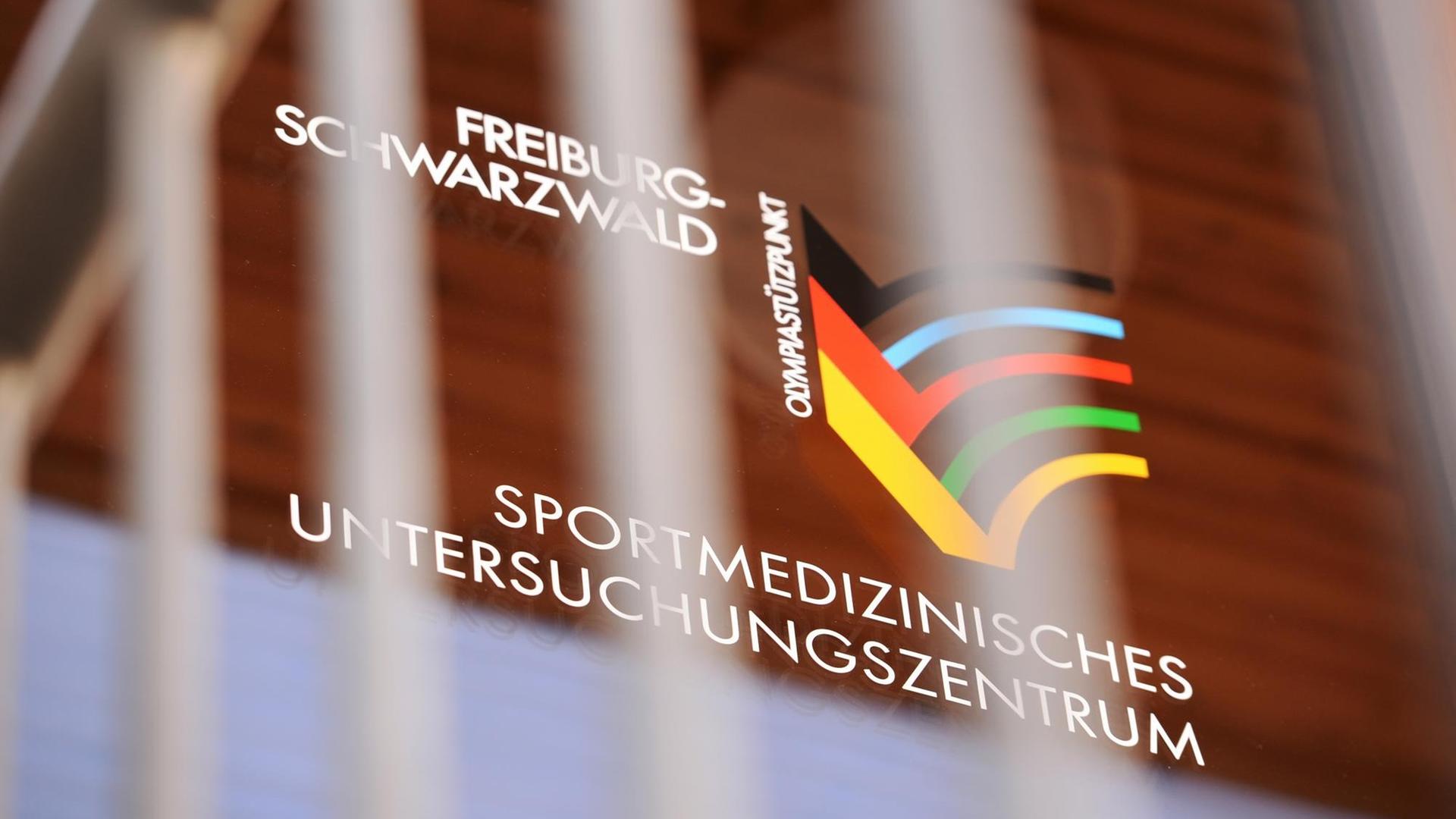 Das Logo des Sportmedizinischen Untersuchungszentrums an der Universitätsklinik in Freiburg am 03.03.2015 an einer Glastür zu sehen.