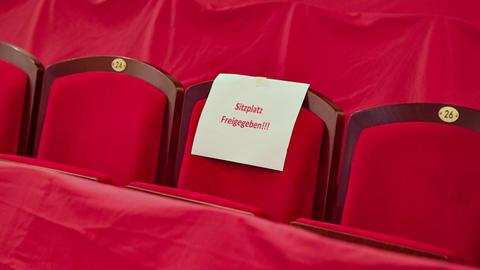 Ein Zettel mit der Aufschrift "Sitzplatz Freigegeben" hängt an einem Sitzplatz im Zuschauerraum des Staatstheaters Cottbus.