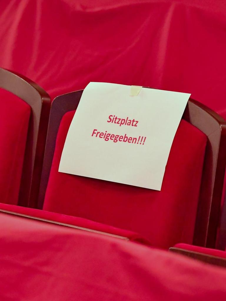 Ein Zettel mit der Aufschrift "Sitzplatz Freigegeben" hängt an einem Sitzplatz im Zuschauerraum des Staatstheaters Cottbus.