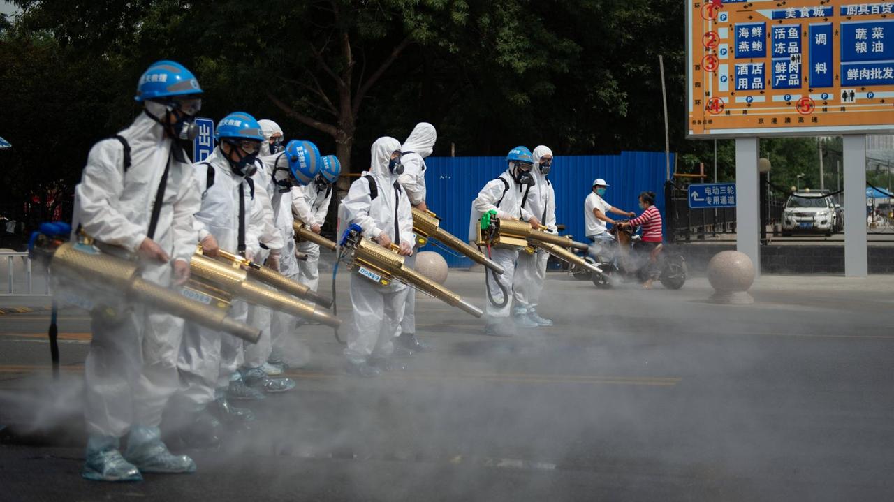 Maskiertes Personal desinfiziert ein Marktgelände in Peking, um den neuen Coronavirus-Ausbruch in der chinesischen Hauptstadt zu stoppen.