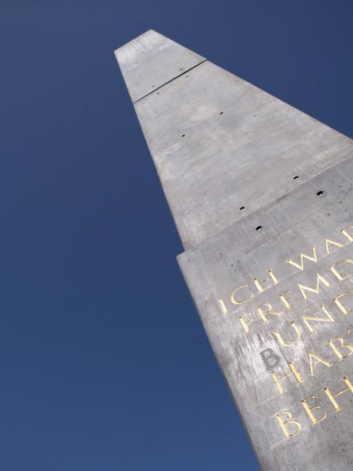 Obelisk von dem aus Nigeria stammenden US-Künstler Olu Oguibe in Kassel auf der documenta 2017. In dem Kunstwerk ist auf den vier Seiten des Jesus-Zitat "Ich war ein Fremdling und ihr habt mich beherbergt" in Deutsch, Türkisch, Englisch und Arabisch eingraviert.