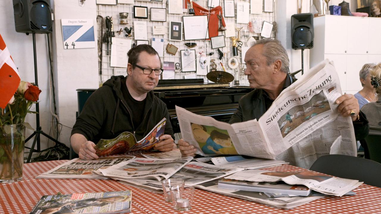 Schauspieler Udo Kier (r.) und der dänische Regisseur Lars von Trier lesen Zeitung in Kopenhagen.