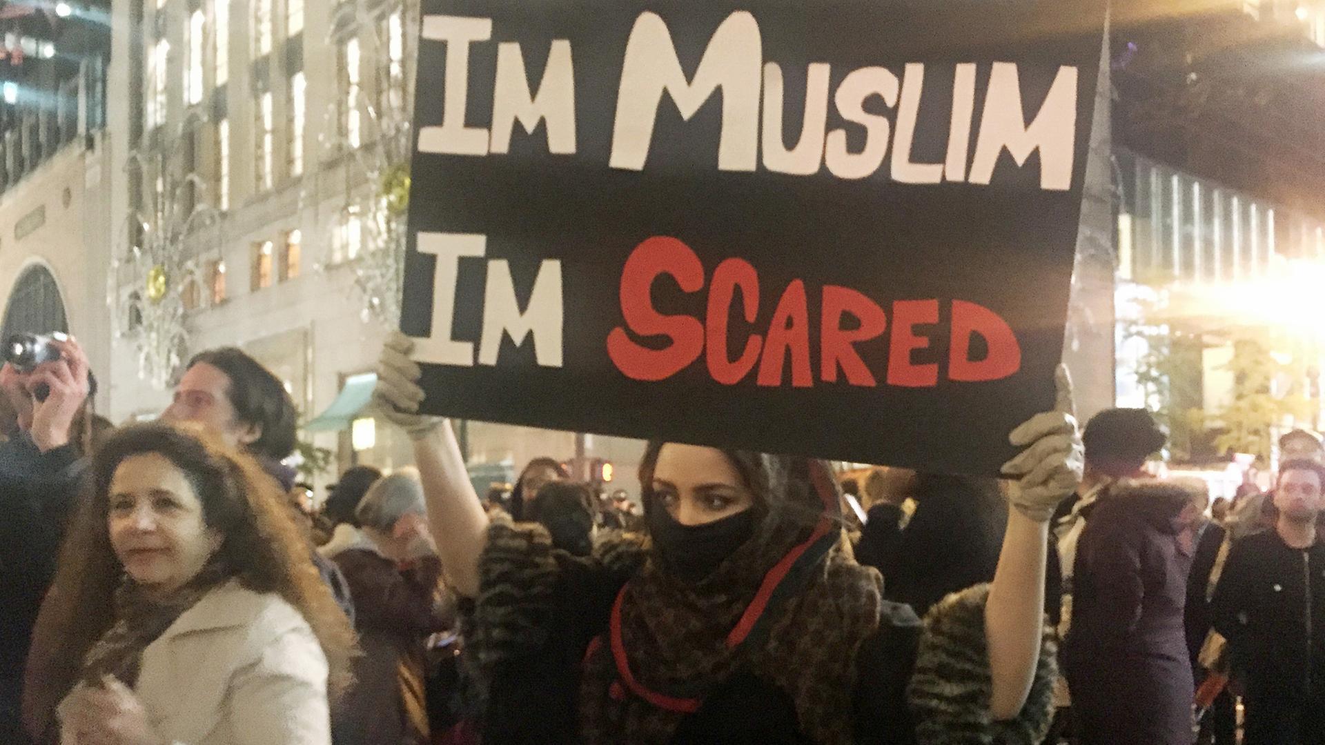 Eine junge Muslima hält in New York, USA, hält bei Protesten gegen die Wahl von Donald Trump zum neuen US-Präsidenten ein Schild mit der Aufschrift "Im Muslim I'm scared" – etwa: "Ich bin Muslima, ich füchte mich" – hoch.