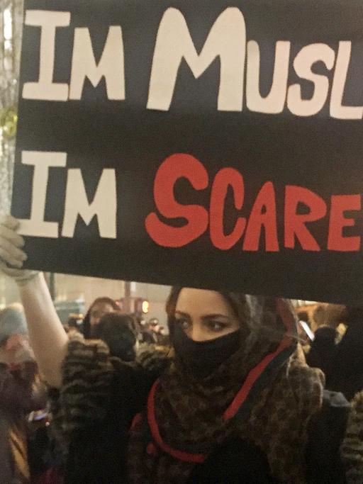 Eine junge Muslima hält in New York, USA, hält bei Protesten gegen die Wahl von Donald Trump zum neuen US-Präsidenten ein Schild mit der Aufschrift "Im Muslim I'm scared" – etwa: "Ich bin Muslima, ich füchte mich" – hoch.