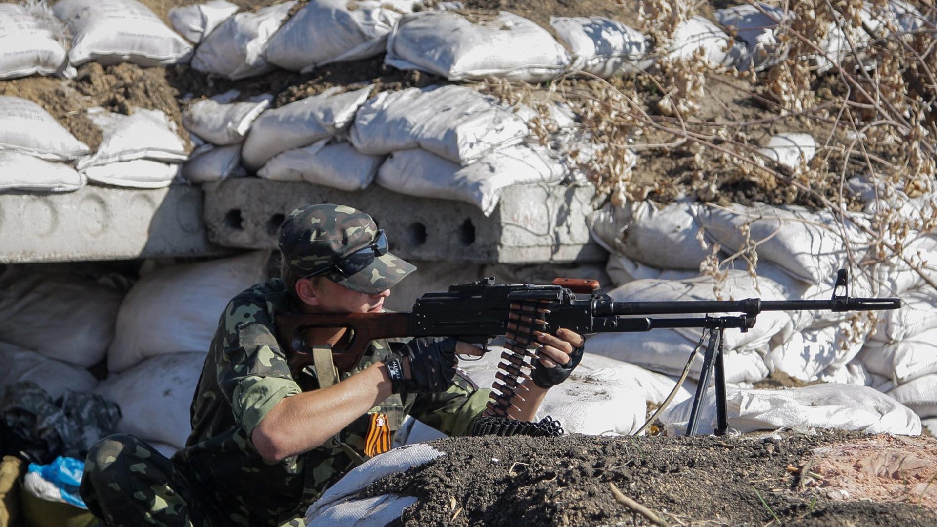 Pro-russische Rebellen gehen am 13.10.2014 bei einer Kontrollstelle nahe Donezk, Ukraine; in Position.