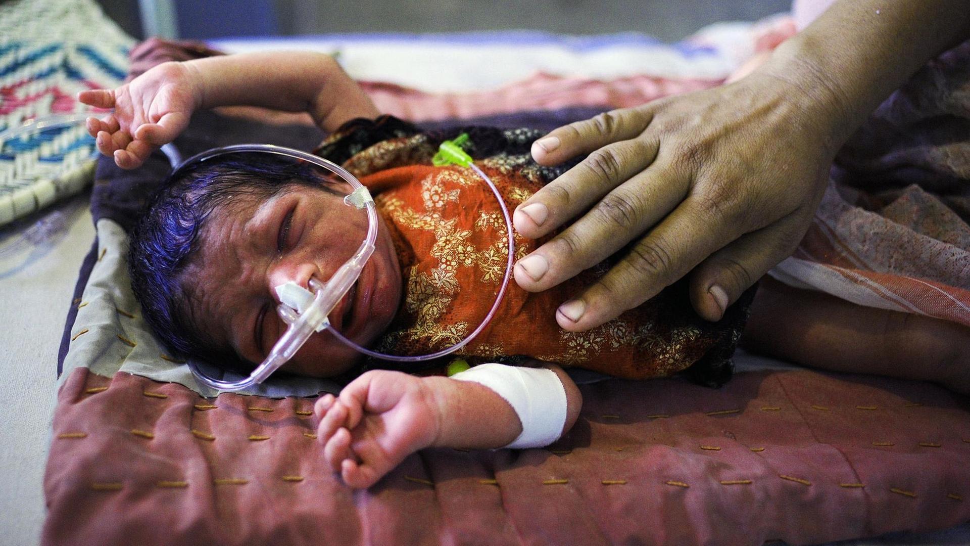 Ein Säugling mit Gastroenteritis in einem Krankenhaus nahe Gehnay Wala in Pakistan. Ein Säugling mit Gastroenteritis in einem Krankenhaus nahe Gehnay Wala in Pakistan.