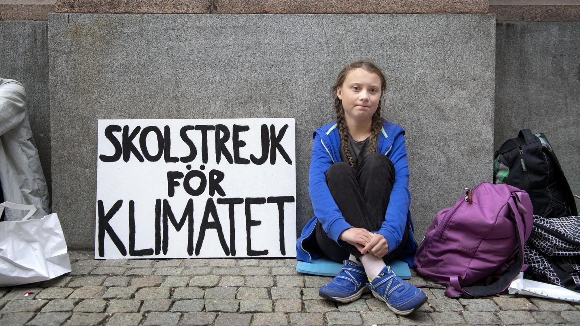 Greta Thunberg sitzt vor dem Parlament in Stockholm.