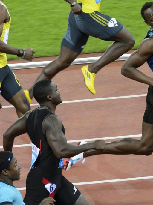 Der jamaikanische Sprinter Usain Bolt (r.) schaut sich nach seinen Mitläufern um.