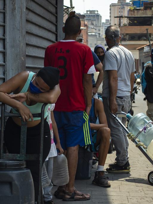 Menschen stehen in Caracas,Venezuela, Schlange um sauberes Wasser abzuholen. 2. April 2020.