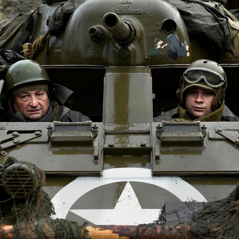 Schauspieler mit Uniformen aus dem 2. Weltkrieg in einem Panzer, den die USA und Großbritannien damals benutzten. 