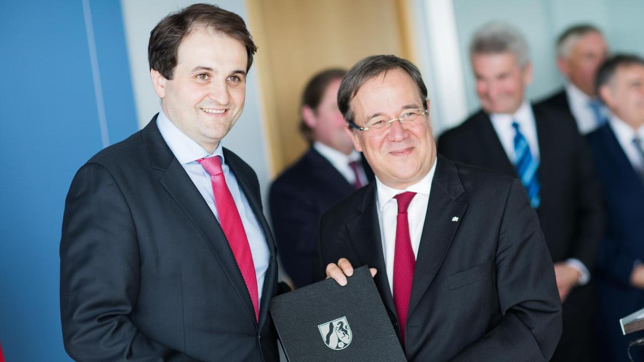 Nathanael Liminski (l), Staatssekretär und Chef der Staatskanzlei, bekommt in der Staatskanzlei in Düsseldorf (Nordrhein-Westfalen) seine Ernennungsurkunde aus den Händen von Ministerpräsident Armin Laschet (CDU).