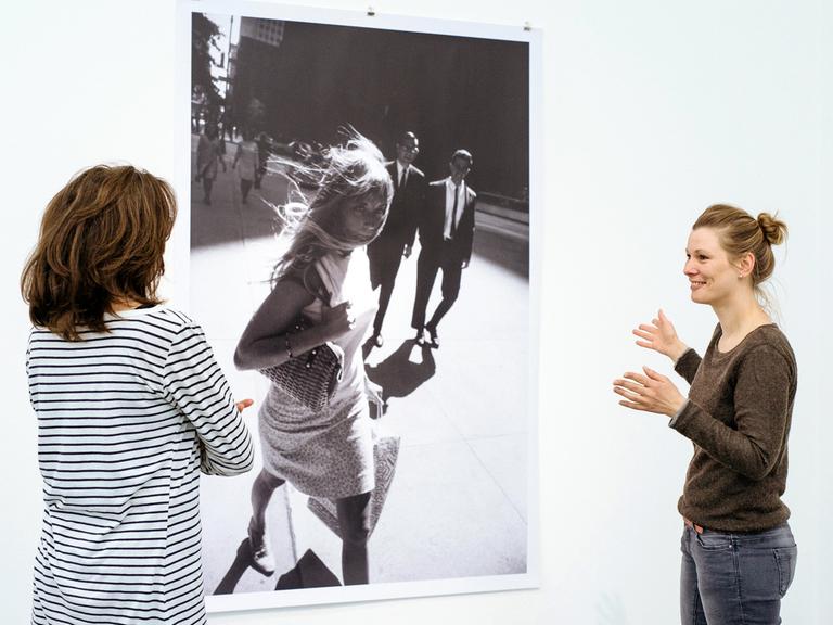 Zwei Ausstellungsbesucherinnen vor einer Schwarz-Weiß-Fotografie mit einer Frau in den Straßen New Yorks von Peter Lindbergh in "Women on Street"