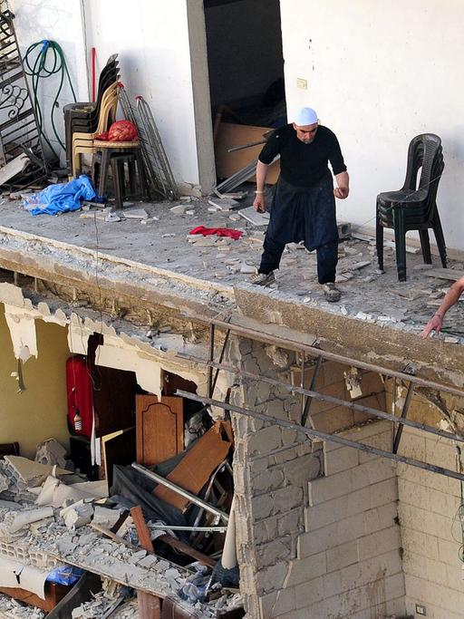 Menschen in einem zerstörten Gebäude nach einer Explosion in Damaskus