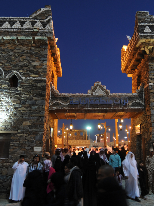 Frauen und Männer vor einem erleuchteten Gebäude beim Kultur-Festival Jandadriyah in der saudi-arabischen Stadt Al-Thamama, 50 Kilometer nördlich der Hauptstadt Riad, im Februar 2014