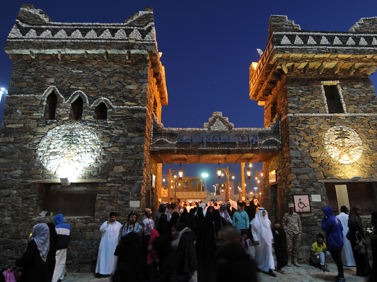 Frauen und Männer vor einem erleuchteten Gebäude beim Kultur-Festival Jandadriyah in der saudi-arabischen Stadt Al-Thamama, 50 Kilometer nördlich der Hauptstadt Riad, im Februar 2014