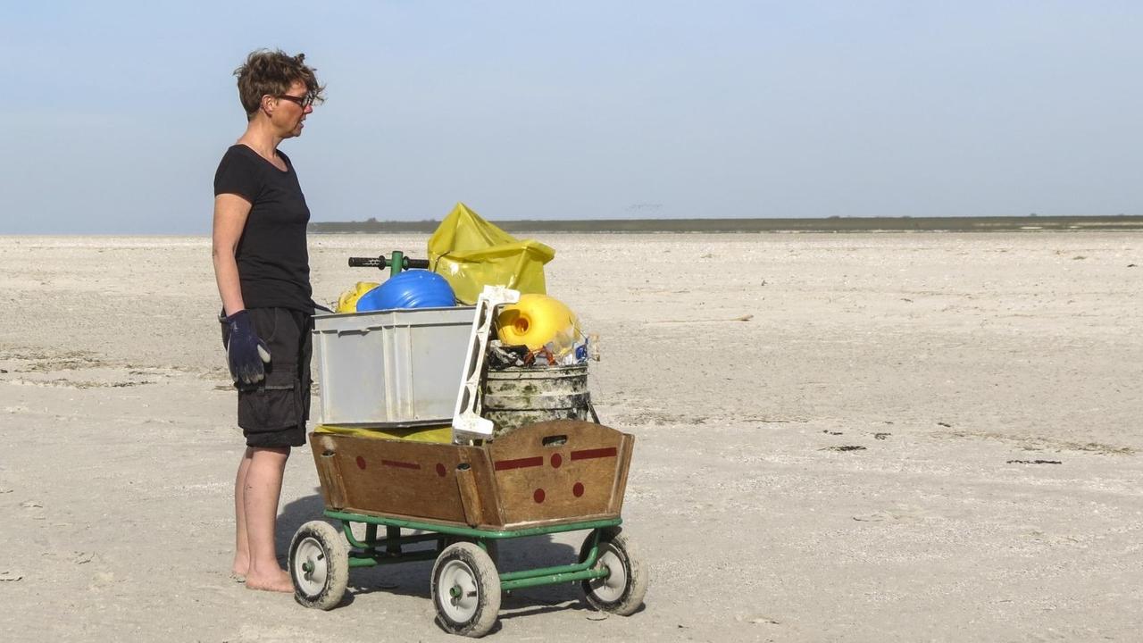 Jennifer Timrott vom Verein "Küste ggen Plastik" im Wattenmeer mit einer Karre voller Plastikmüll.