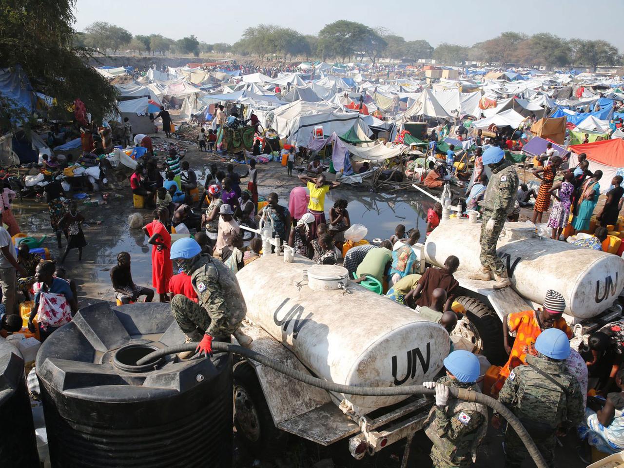 Südkoreanische UNO-Soldaten verteilen Wasser an ein Flüchtlingslager im Südsudan, das aus vielen Zelten und Hunderten Menschen besteht. Südkoreanische UNO-Soldaten verteilen Wasser an ein Flüchtlingslager im Südsudan, das aus vielen Zelten und Hunderten Menschen besteht.