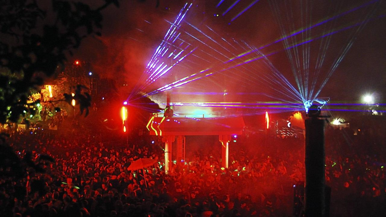 Laser-Lichtinstallation an der Turmbühne auf dem Fusion Festival. Unter der Bühne stehen Tausende Menschen, die tanzen. 