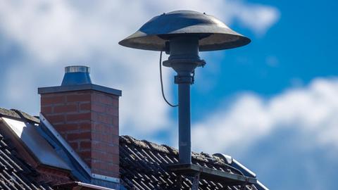 Eine Alarmsirene steht auf einem Hausdach.