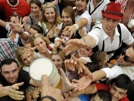 Besucher des Oktoberfestes greifen in München im Hofbräuzelt nach der Eröffnung des Festes nach einer Maß Freibier. Das Fest endet am 3. Oktober 2011 statt.