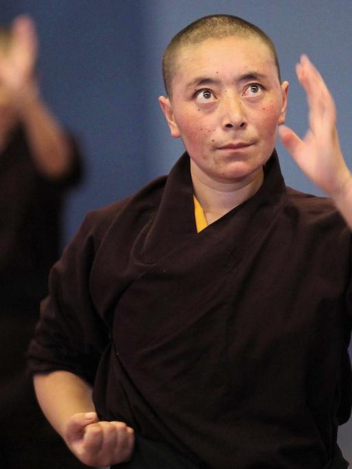 Junge Buddhistische Nonnen mit kurz geschorenen Haaren während der Kung-Fu Übungung.