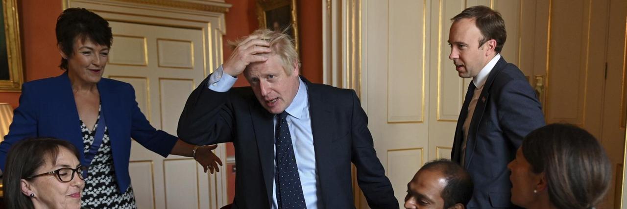 Das Foto zeigt den britischen Premierminister Boris Johnson. Er spricht mit Vertretern des Gesundheitssystems.